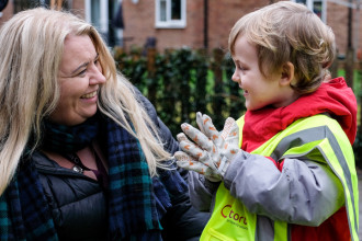 Photo of a woman talking to a child wearing a high visibility jacket
