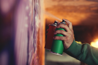 Photo of someone spraying paint onto a wall