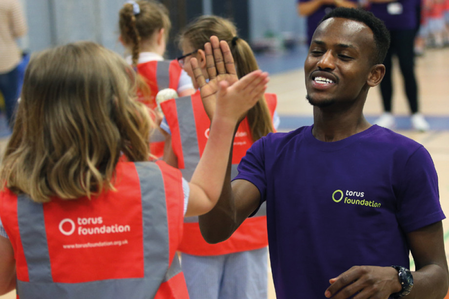 Photo of a Torus Foundation member of staff giving a high five to a young person