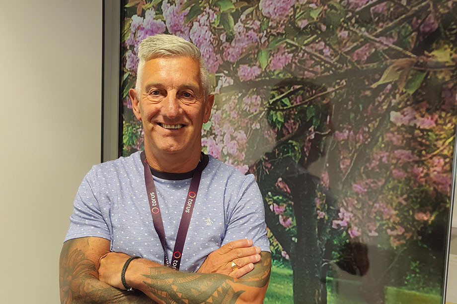 Torus colleague James Mcgarry stood with arms folded in front of an image of a tree