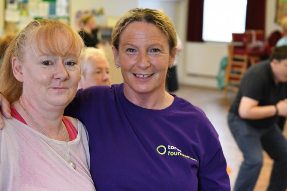 Photo of a Torus Foundation member of staff with her arm around a customer