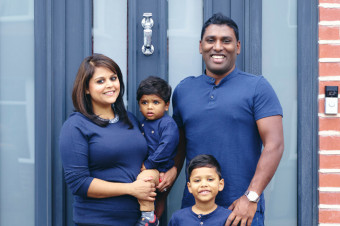 Photo of a young family of five stood in front of a front door